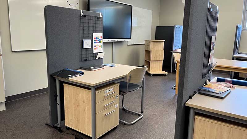 Ett skrivbord med avskärmningar i ett klassrum